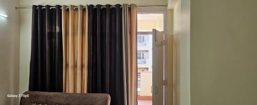 a window with black curtains in a room at Radha Krishna Sharnam in Chhatikara