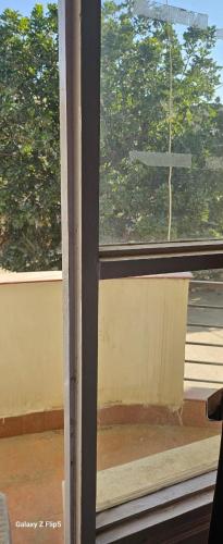 an open window with a view of a tree at Radha Krishna Sharnam in Chhatikara