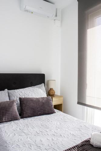 a bed with two pillows and a window in a bedroom at Gaviotas Beach Golf in Almerimar