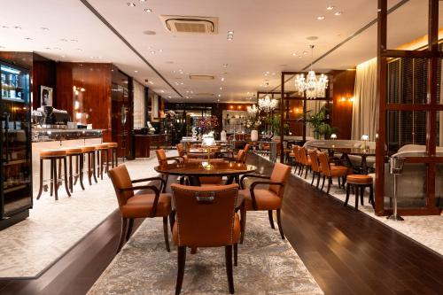 Un restaurante con mesas y sillas y un bar. en Hotel Royal Plovdiv, en Plovdiv