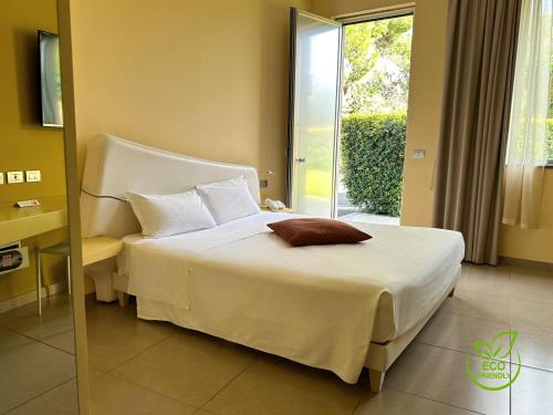 a bedroom with a white bed and a window at ibis Styles Catania Acireale in Acireale