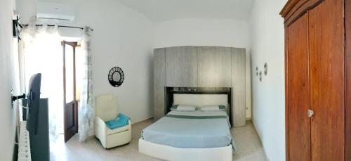 a bedroom with a bed and a chair in it at La casa nel borgo in Termoli