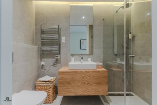 a bathroom with a sink and a mirror and a shower at Shore Apartments - Santa Cruz in Santa Cruz