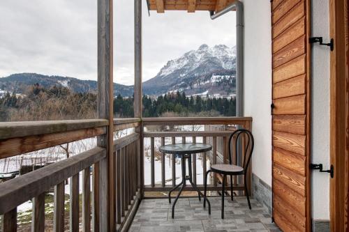 a balcony with a table and chairs and a view of a mountain at Agritur Maso Flonkeri in Bosentino