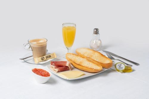 a plate of food with bread and a glass of champagne at Hostal Pensimar in El Altet