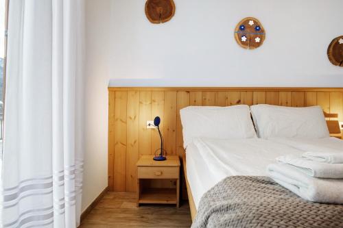 a bedroom with a bed with a wooden headboard at Agritur Maso Flonkeri in Bosentino