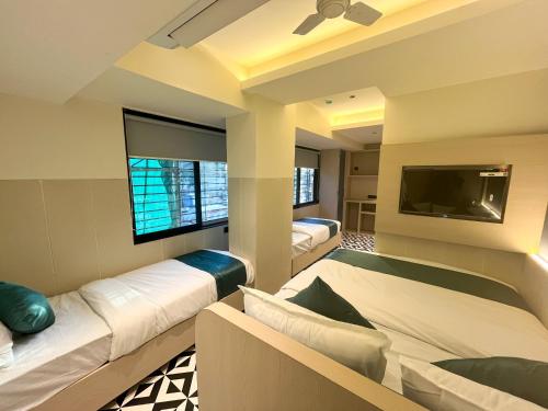 a bedroom with two beds and a flat screen tv at Bandra Stays in Mumbai
