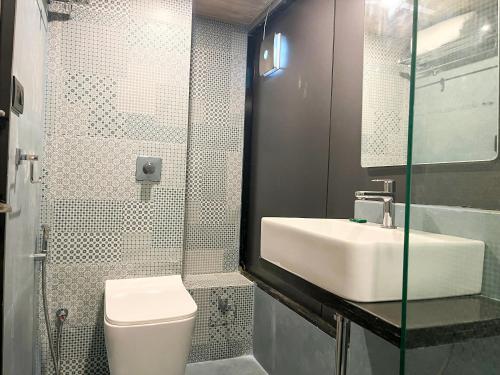 a bathroom with a sink and a toilet and a shower at Bandra Stays in Mumbai