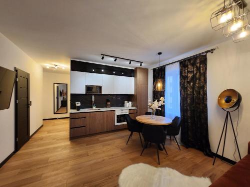 a living room with a table and a kitchen at New! Warsaw Luxury Apartment with Jacuzzi and total relax - Warszawski Luksus Jacuzzi i totalny relaks! in Warsaw