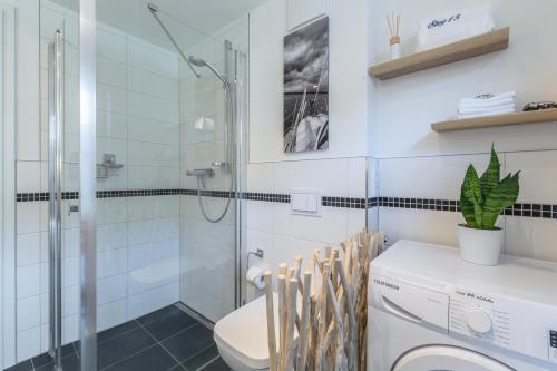 a bathroom with a toilet and a glass shower at Alte Fischfabrik in Putbus