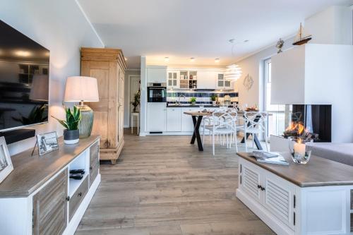 a kitchen and living room with white cabinets and a table at Alte Fischfabrik in Putbus