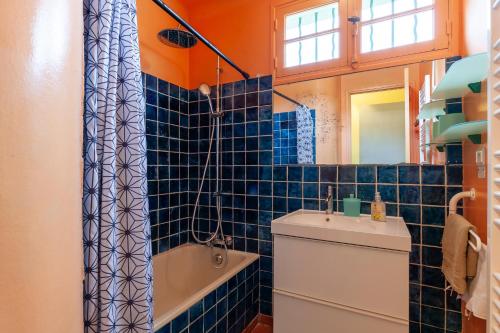 La salle de bains est pourvue de carrelage bleu, de toilettes et d'un lavabo. dans l'établissement Lou Jas - Cassis, à Cassis