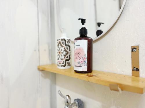 a bathroom shelf with a bottle of soap and a mirror at Bohaus in Alastuwo