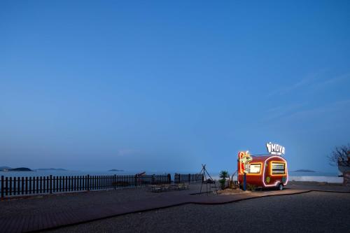 a bus parked on the side of a beach at Moya Resort Hotel-Near Laoshan Scenic Area,Free Private Beachcombing, Free DIY Experience, 3 Free Photographers' Photos, Paid provision Featured Seafood in Qingdao
