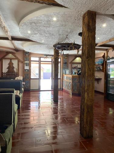 a large room with a stone floor and a lobby with couches at Готель-кафе Чатина in Soymy