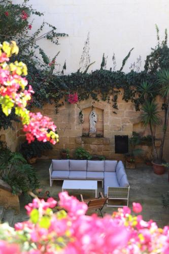 a living room with a couch and some flowers at Charming Xagħra Farmhouse with Pool, Garden & Spacious, Gozo by 360 Estates in Xagħra