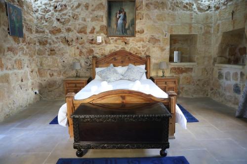 a bedroom with a wooden bed and two night stands at Charming Xagħra Farmhouse with Pool, Garden & Spacious, Gozo by 360 Estates in Xagħra