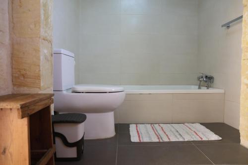 a bathroom with a toilet and a bath tub at Charming Xagħra Farmhouse with Pool, Garden & Spacious, Gozo by 360 Estates in Xagħra