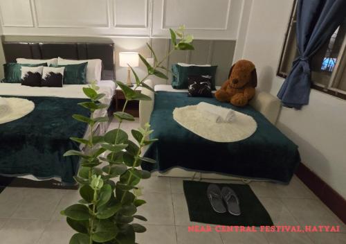 a room with two beds with a teddy bear sitting on a bed at SridaHouse#Near Central Festival Hat Yai in Sathani Khlong Rian