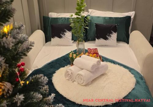 a room with two towels and a christmas tree at SridaHouse#Near Central Festival Hat Yai in Sathani Khlong Rian