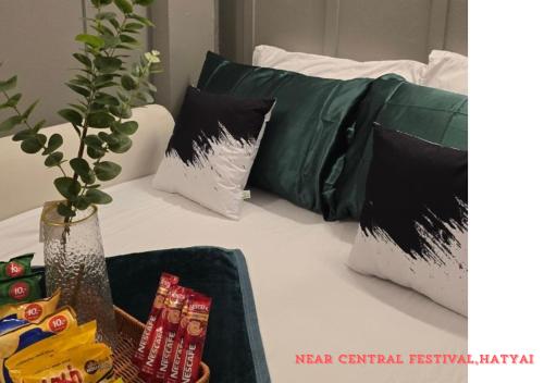 a bed with pillows and a tray of food on it at SridaHouse#Near Central Festival Hat Yai in Sathani Khlong Rian