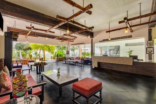 an open living room with tables and chairs at Sterling Palavelli Godavari in Rāzole