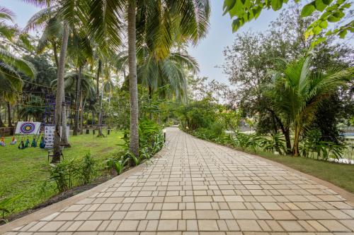 a walkway in a park with palm trees at Sterling Palavelli Godavari in Rāzole