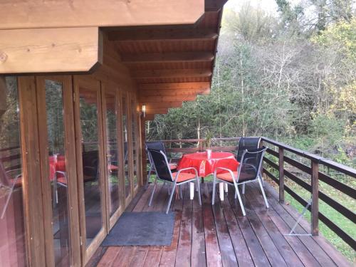 a table and chairs on the deck of a cabin at Ferienhaus Blockhaus by Seeblick Ferien Edersee in Waldeck