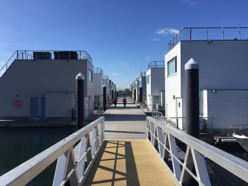 ein Gehweg, der zu einem Steg neben dem Wasser führt in der Unterkunft Schwimmendes Ferienhaus Antares One by Seeblick Ferien ORO, rundum Wasser, Sauna in Olpenitz