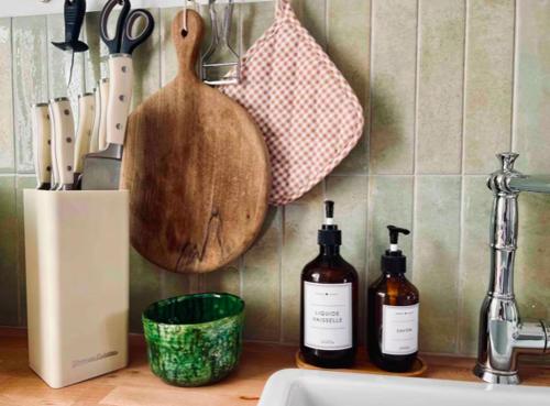 - un comptoir de cuisine avec 2 bouteilles de vin et un évier dans l'établissement le petit George, T3 terrasse et front de mer classé 3 étoiles, à Palavas-les-Flots