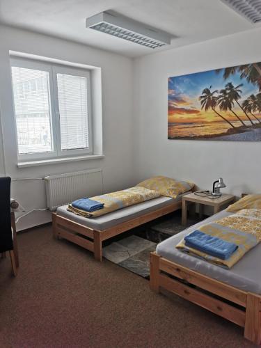 a room with two beds and a painting on the wall at LIVING BRATISLAVA by the BUS STATION in Bratislava