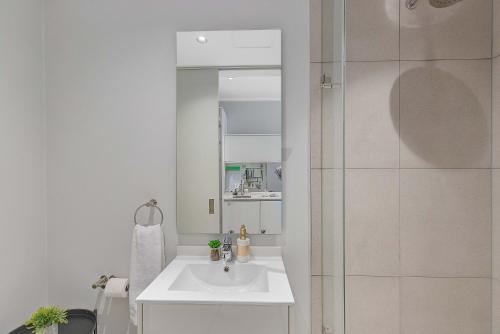 a white bathroom with a sink and a shower at Bhonsane Executive Suite, Ellipse, Midrand in Midrand