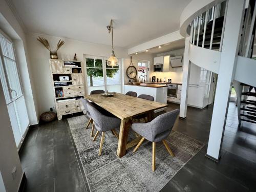 a kitchen with a wooden table and chairs at Traumferienhaus Sliminde by Seeblick Ferien ORO, direkte Wasserlage E-Säule 6 Pers in Olpenitz