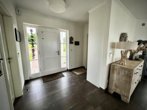 a room with a hallway with a table and windows at Traumferienhaus Sliminde by Seeblick Ferien ORO, direkte Wasserlage E-Säule 6 Pers in Olpenitz