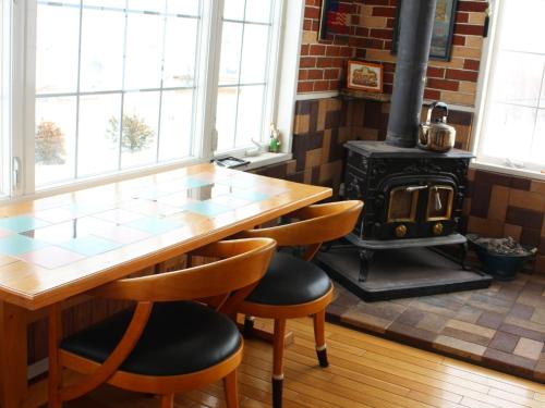 eine Küche mit einem Holztisch und einem Holzofen in der Unterkunft Furano - Hotel / Vacation STAY 35850 in Furano