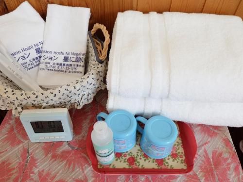 ein Tablett mit zwei Tassen, einer Waage und Handtüchern in der Unterkunft Furano - Hotel / Vacation STAY 35850 in Furano