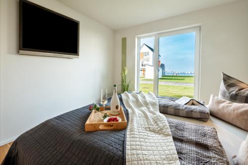 a bedroom with a bed with a tray of food on it at Fewo MEERwert by Seeblick Ferien ORO, Familienfreundlich, Sauna, Kamin,XL Dusche in Olpenitz