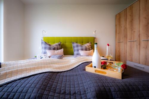 a bedroom with a bed with a green headboard at Fewo MEERwert by Seeblick Ferien ORO, Familienfreundlich, Sauna, Kamin,XL Dusche in Olpenitz