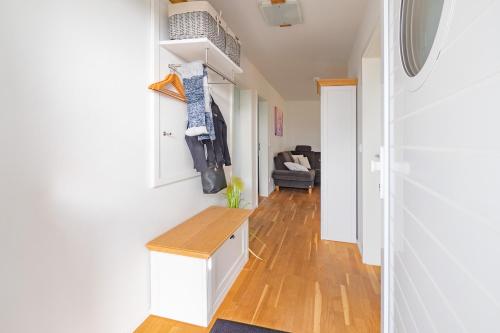 a hallway with white walls and wooden floors at Fewo MEERwert by Seeblick Ferien ORO, Familienfreundlich, Sauna, Kamin,XL Dusche in Olpenitz