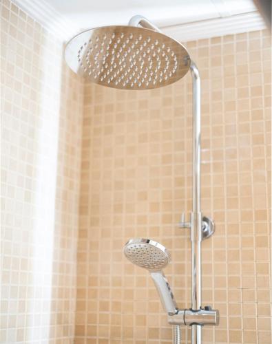a shower with a shower head in a bathroom at EnjoyGranada New Suite EMIR in Granada