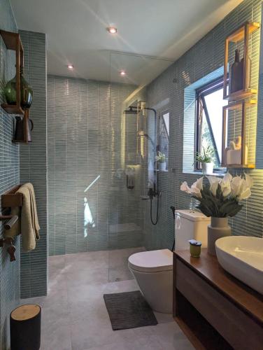 a bathroom with a shower and a toilet and a sink at The Green Door in Ella