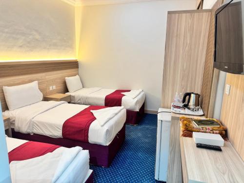 a hotel room with two beds and a television at فندق رفاق العالية in Makkah