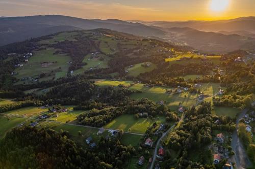 an aerial view of a golf course in the mountains at sunset at Domki 4 pory roku in Koniaków