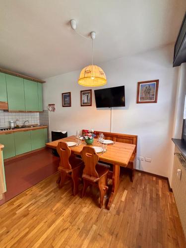 una sala da pranzo con tavolo e sedie in legno di Bilocale sulle Piste a Sappada nelle Dolomiti a Sappada
