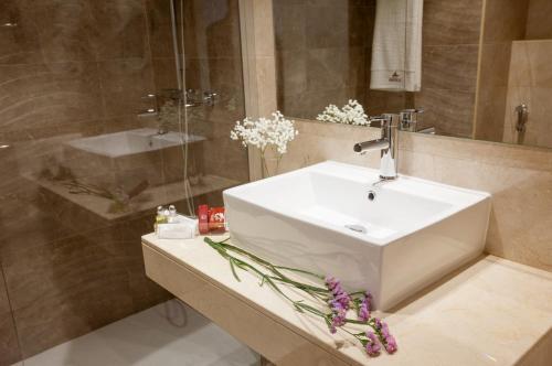 y baño con lavabo blanco y espejo. en Hotel Insula Barataria, en Alcázar de San Juan