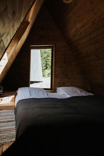 a bedroom with a bed and a window in a attic at УЛІС Ворохта in Ilʼtsya Gurny