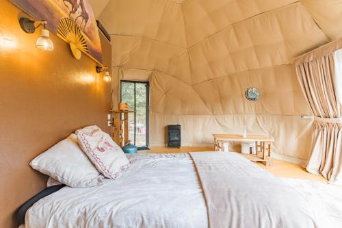a bedroom with a bed in a tent at La Cabane aux Chevaux in Varages