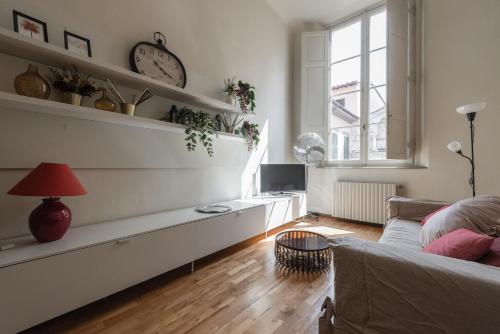 a living room with a couch and a clock on the wall at Single House in Pisa