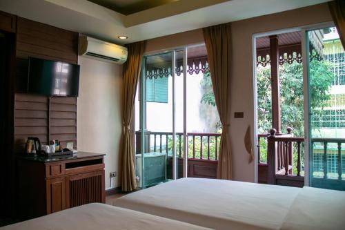 Ένα ή περισσότερα κρεβάτια σε δωμάτιο στο Lamphu Tree House Boutique Hotel