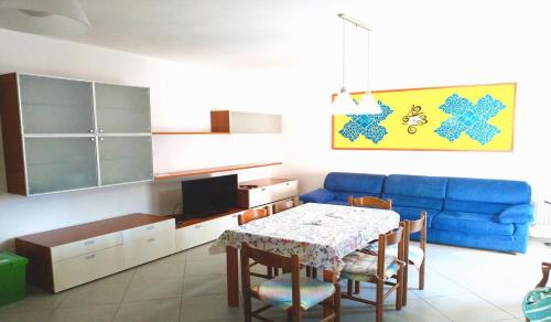 a living room with a table and a blue couch at Gelsomino in Marina di Campo